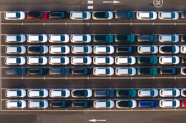  An aerial view directly above rows of newly built cars at a port