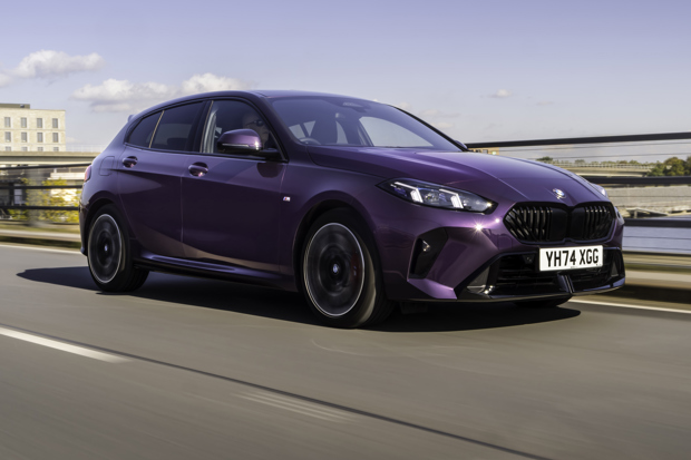 BMW 1 Series driving on clear road out of city